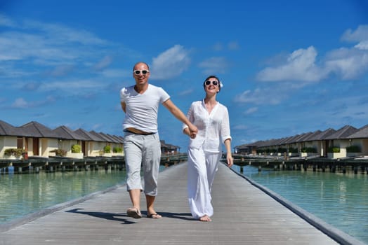 happy young couple have fun and relax at summer vacation on background maldives travel location and beautiful white sand beach