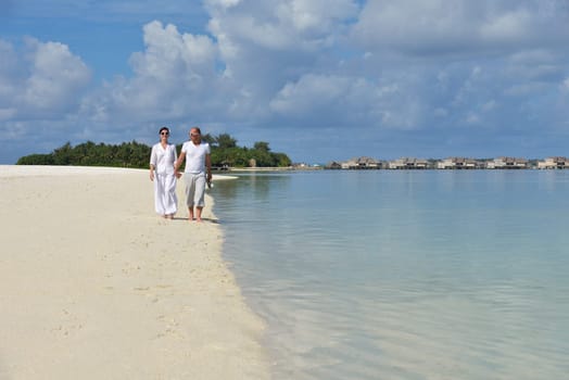 happy young couple have fun and relax at summer vacation on background maldives travel location and beautiful white sand beach