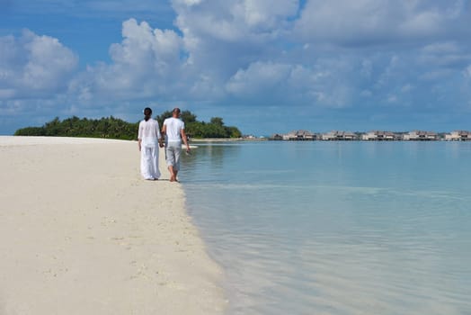happy young couple have fun and relax at summer vacation on background maldives travel location and beautiful white sand beach