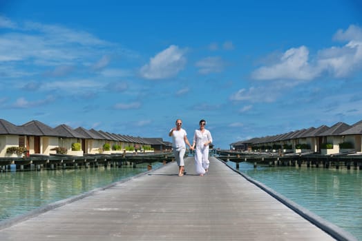 happy young couple have fun and relax at summer vacation on background maldives travel location and beautiful white sand beach