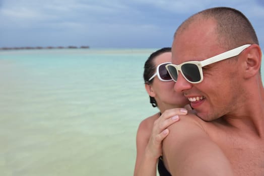 happy young couple have fun and relax at summer vacation on background maldives travel location and beautiful white sand beach