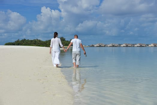 happy young couple have fun and relax at summer vacation on background maldives travel location and beautiful white sand beach