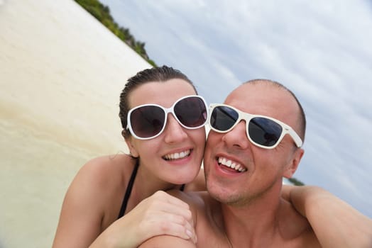 happy young couple have fun and relax at summer vacation on background maldives travel location and beautiful white sand beach