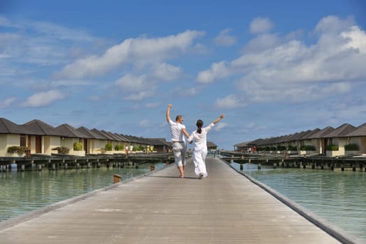 happy young couple have fun and relax at summer vacation on background maldives travel location and beautiful white sand beach