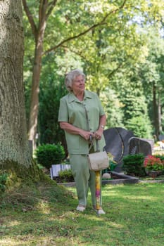 Elderly lady walks across a Fiedhof