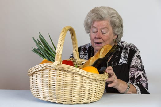 Elderly lady looks at her shopping basket