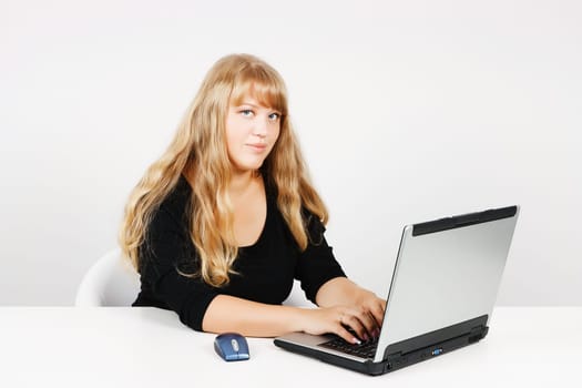 Blond girl with laptop in the office
