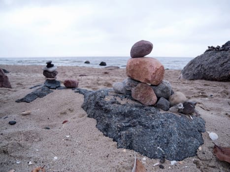 superimposed pebbles on the North Sea coast under cloudy skies in frog perspective