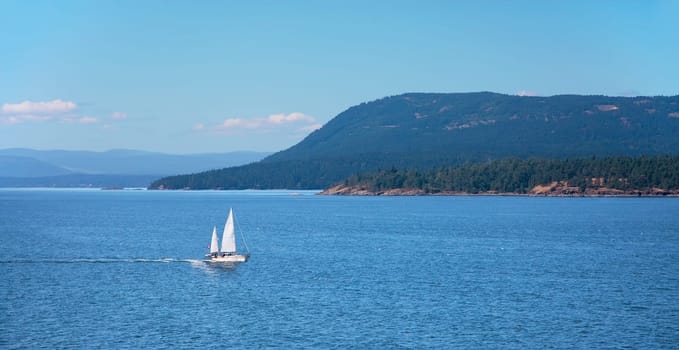 Shot from the deck of a BC Ferry while travelling between Vancouver and Victoria. Mayne Island can been seen behind a sailboat.