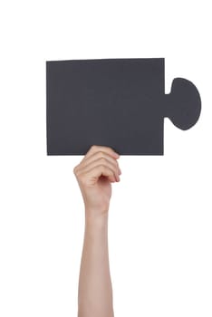 Hand Holding a Black Piece of a Puzzle, Isolated