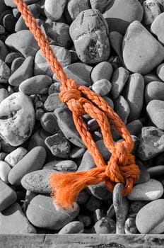 orange rope on the beach of gray stones