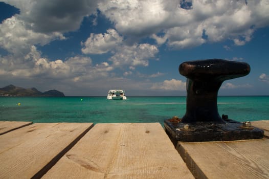 small wooden jetty overlooking a catamaran