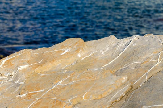 yellow rock on the blue sea in Genoa