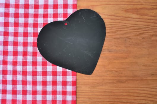 a black heart red rarized bow on wooden background
