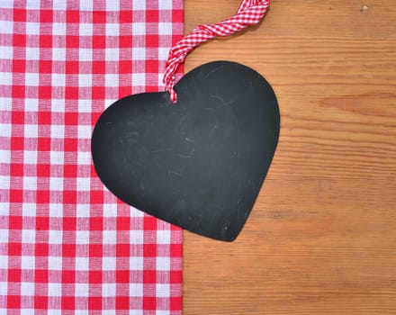 a black heart red rarized bow on wooden background