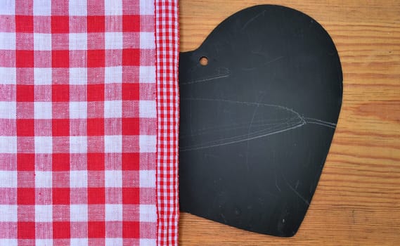 a black heart red rarized bow on wooden background