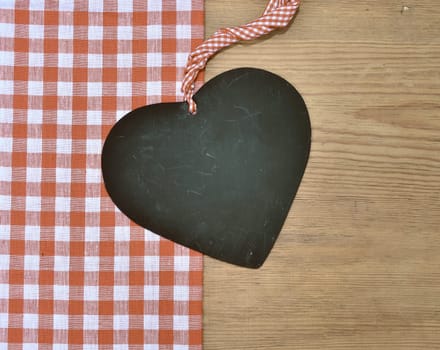 a black heart red rarized bow on wooden background