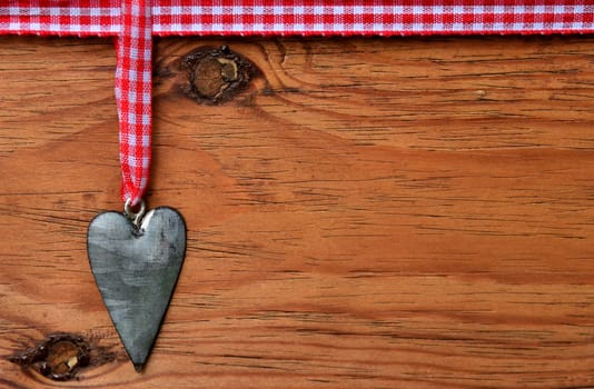 a black heart red rarized bow on wooden background