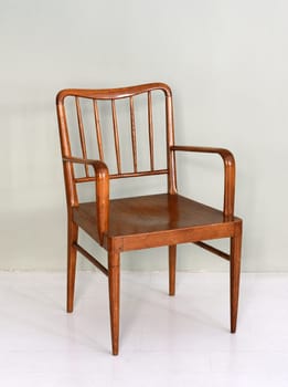 Classic wooden lacquered chair close-up on white floor near the wall