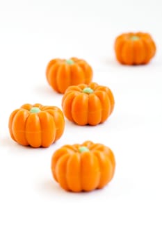 Colorful group of halloween candy in shape of pumpkins on white background. Also useful as autumn concept.