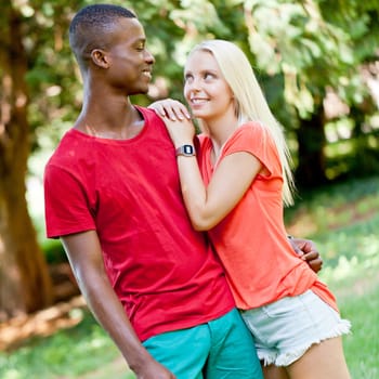 Young in love multicultural couple on a meadow in summer leisure fun