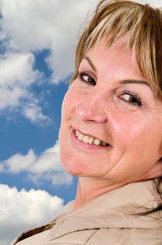 Head-and-shoulder portrait of a middle-aged woman with a smiling look over her shoulder