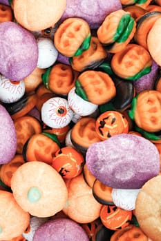 Colorful group of halloween candy in shape of pumpkins and skulls with funny, smiley faces.