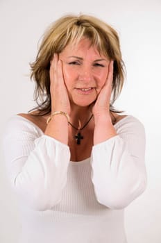 Upper body shot of a middle-aged woman touching her temples in pain