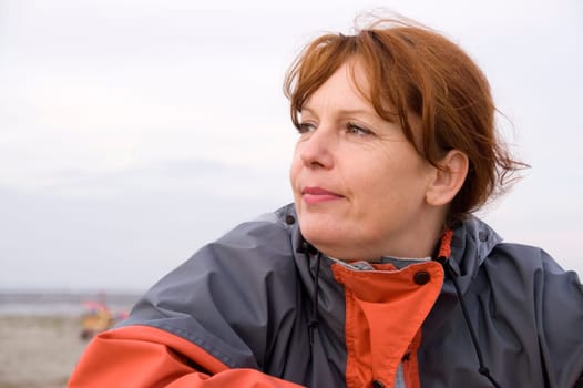 Head and shoulder portrait of a middle-aged woman on the North German beach with a view to the side