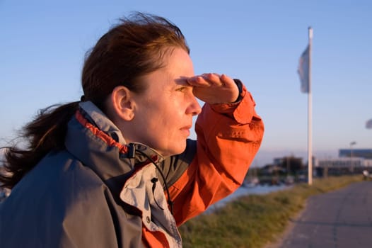 Upper body profile of a middle-aged woman looking into the sun