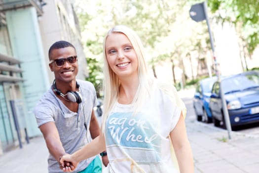 Young multicultural couple in love laughing in the city in summer