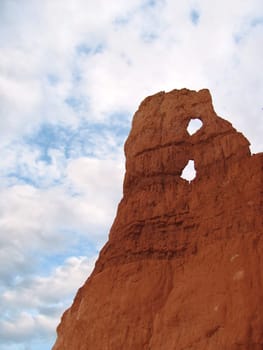 Red rock monument with arches over blue sky in the desert