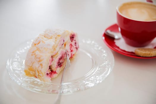 Attractive dessert on white plate next to cofee