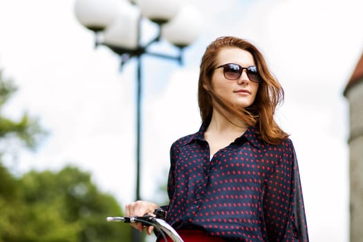 Woman on bicycle in sunglasses looking at far