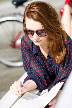 Young woman lying on bench and enjoys reading