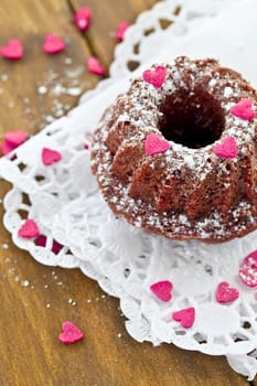 Small Gugelhupf with pink sugar hearts and icing sugar