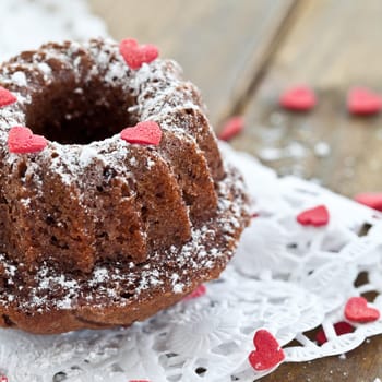 Small Gugelhupf with pink sugar hearts and icing sugar