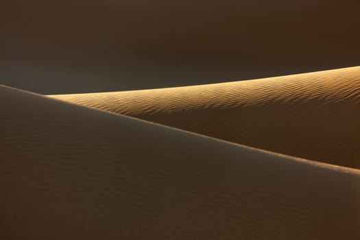 Sand dunes with deep shadows in the Sahara desert of Morocco.