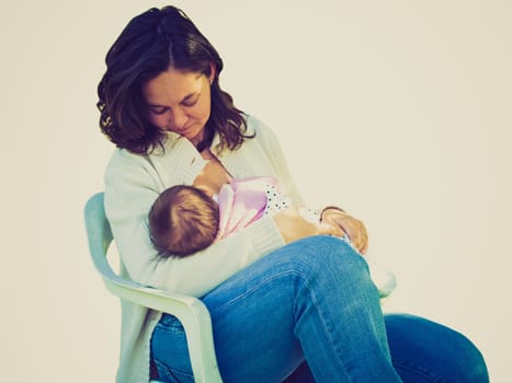 Vintage look Pretty young mum breastfeeding her baby