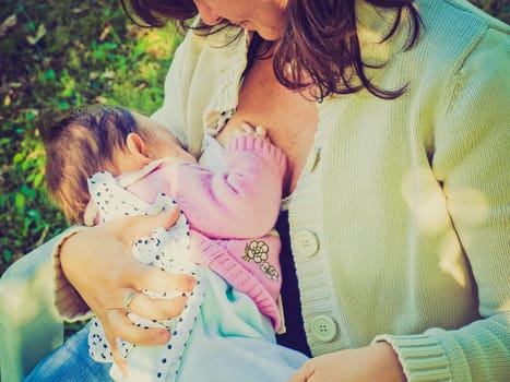 Vintage look Pretty young mum breastfeeding her baby