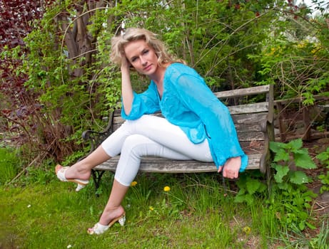 Young woman sitting on wooden bench
