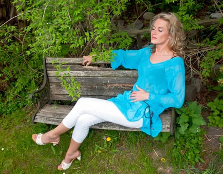 Young woman sitting on wooden bench