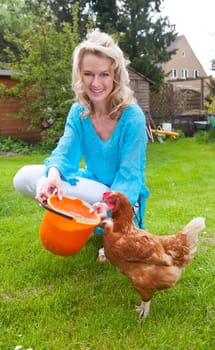Woman feeds chicken