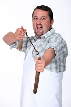 Angry butcher fighting with sausages