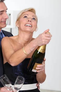 couple opening a bottle of champagne