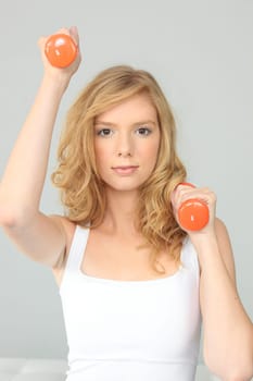 Attractive young woman working out with dumbbells