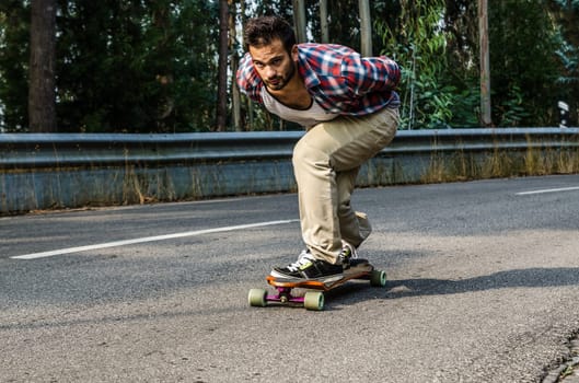 Downhill skateboarder in action on a asphalt road.