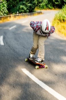 Downhill skateboarder in action on a asphalt road.
