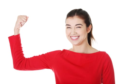 Young woman shows her biceps. Isolated on the white background.