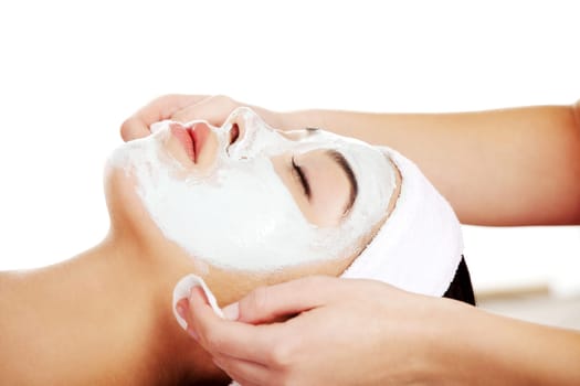 Beauty treatment in spa salon. Woman with facial clay mask.